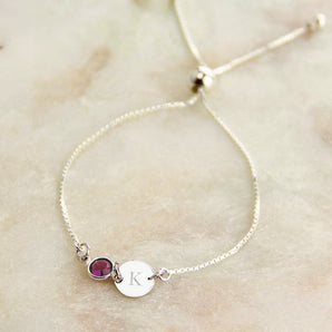 Silver bracelet with an amethyst birthstone and initial charm 