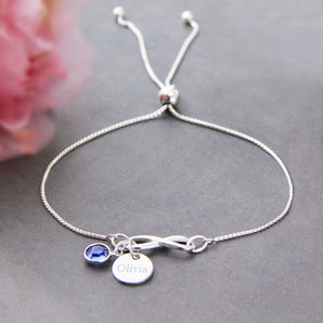 Sterling Silver Infinity Birthstone Sliding Bracelet with September birthstone and engraved disc charm displayed on a grey background