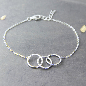 Three Linked Circles Sterling Silver Bracelet displayed on a grey surface