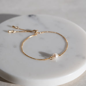 Gold Filled Sliding Pearl Bracelet Adjustable displayed on a marbled surface
