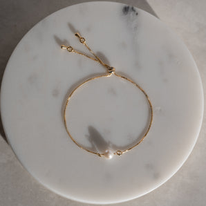 Gold Filled Sliding Pearl Bracelet Adjustable displayed on a marbled surface