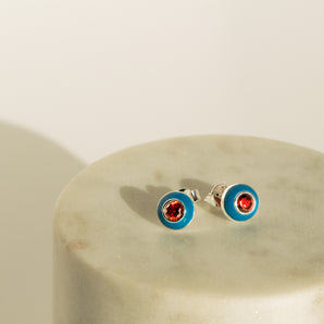 Sterling Silver Blue And Red Enamel Stud Earrings displayed on a marbled surface