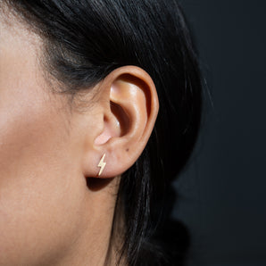 Gold Filled Lightning Bolt Stud Earrings shown worn in a model's ear