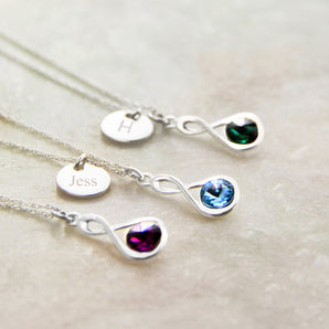 Silver necklace with birthstone in an infinity setting and engraved disc charm attached