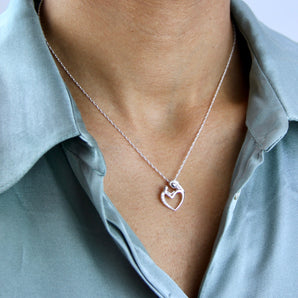 Sterling Silver Mother And Child Pendant Heart Necklace shown worn around a model's neck
