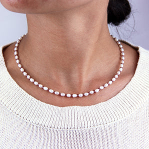 Sterling Silver Seed Pearl And Birthstone Necklace shown worn around a model's neck