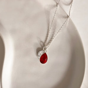 Pear shaped red birthstone and leaf charm on sterling silver chain