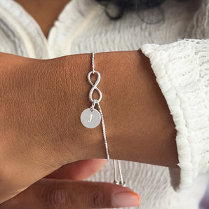 Sterling Silver Infinity Adjustable Sliding Bracelet with engraved disc charm shown worn around a model's wrist