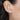 Close-up of an ear wearing a silver heart earring.