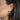 Close-up of an ear wearing a pearl earring with dark hair.