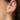 Close-up of an ear wearing a pink teardrop earring