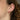 Close-up of an ear wearing a pink earring with a blurred background