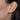 Close-up of an ear with a gold crescent moon pull through hoop earring