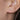 Close-up of an ear wearing a gold crescent moon earring.