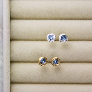 Silver and gold birthstone nest studs displayed in a jewellery box