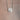 Silver necklace with an angel wing pendant on a beige background