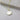 Gold necklace with a round pendant on a light grey surface