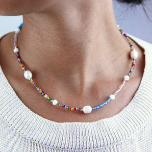 Rainbow Multicoloured Seed Bead And Pearl Necklace shown worn around a model's neck