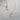 silver and gold crescent moon and star necklaces on grey backround