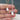 gold and silver bee necklaces against persons hand