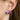 Close-up of an ear wearing colourful hoop earrings with a blurred background.